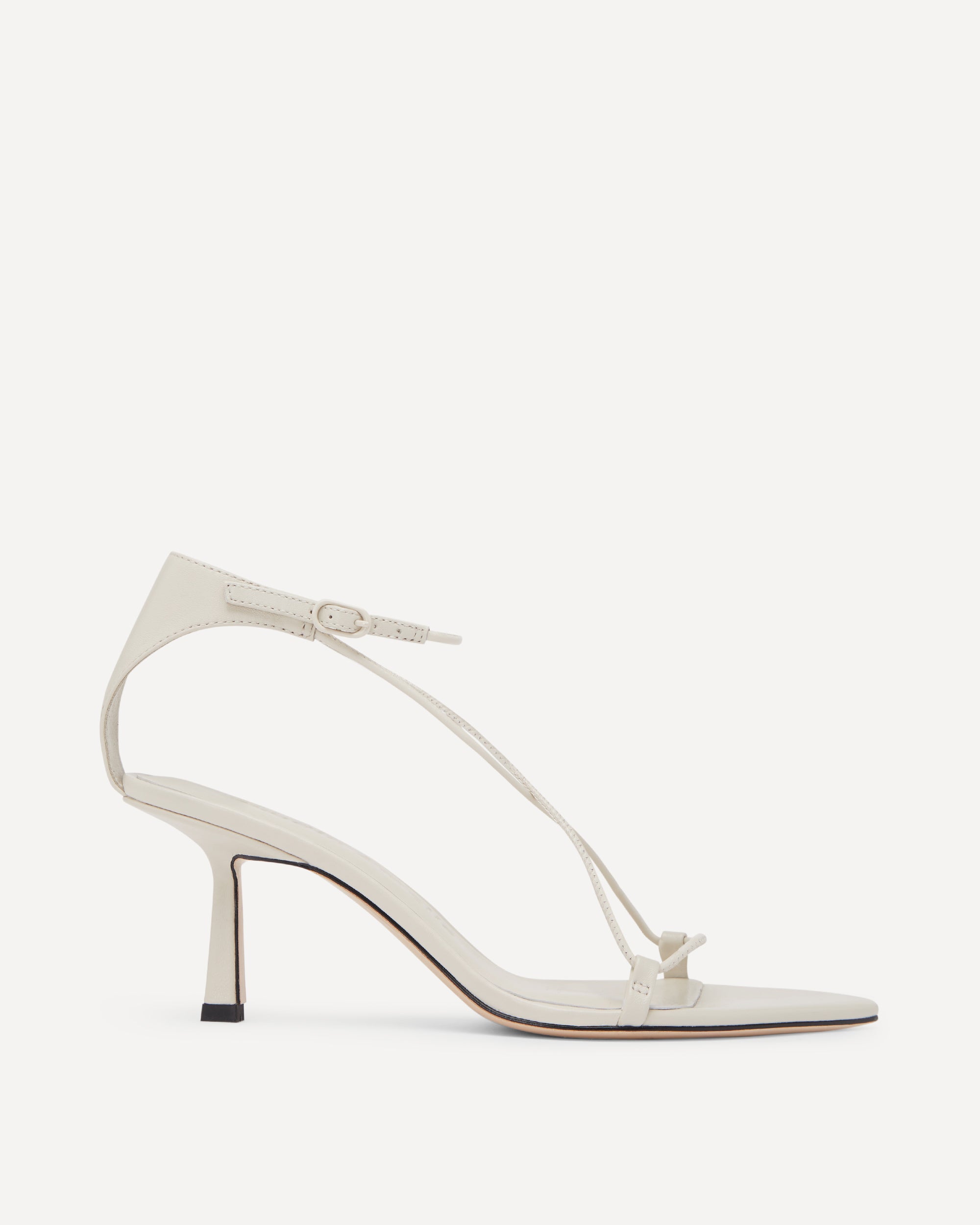 White sandal with thin strap and pointed toe on a white background