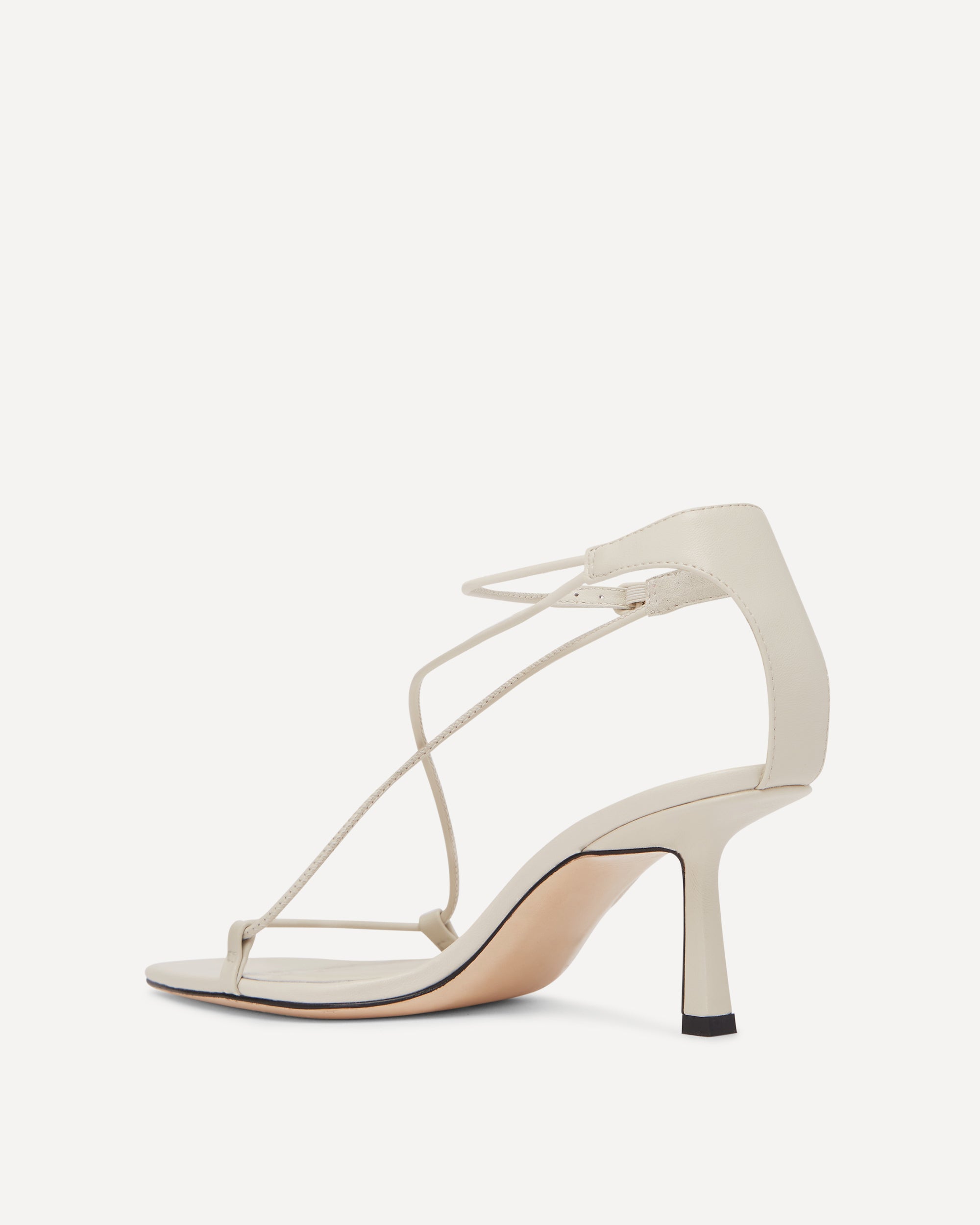 White sandal with thin straps on a white background
