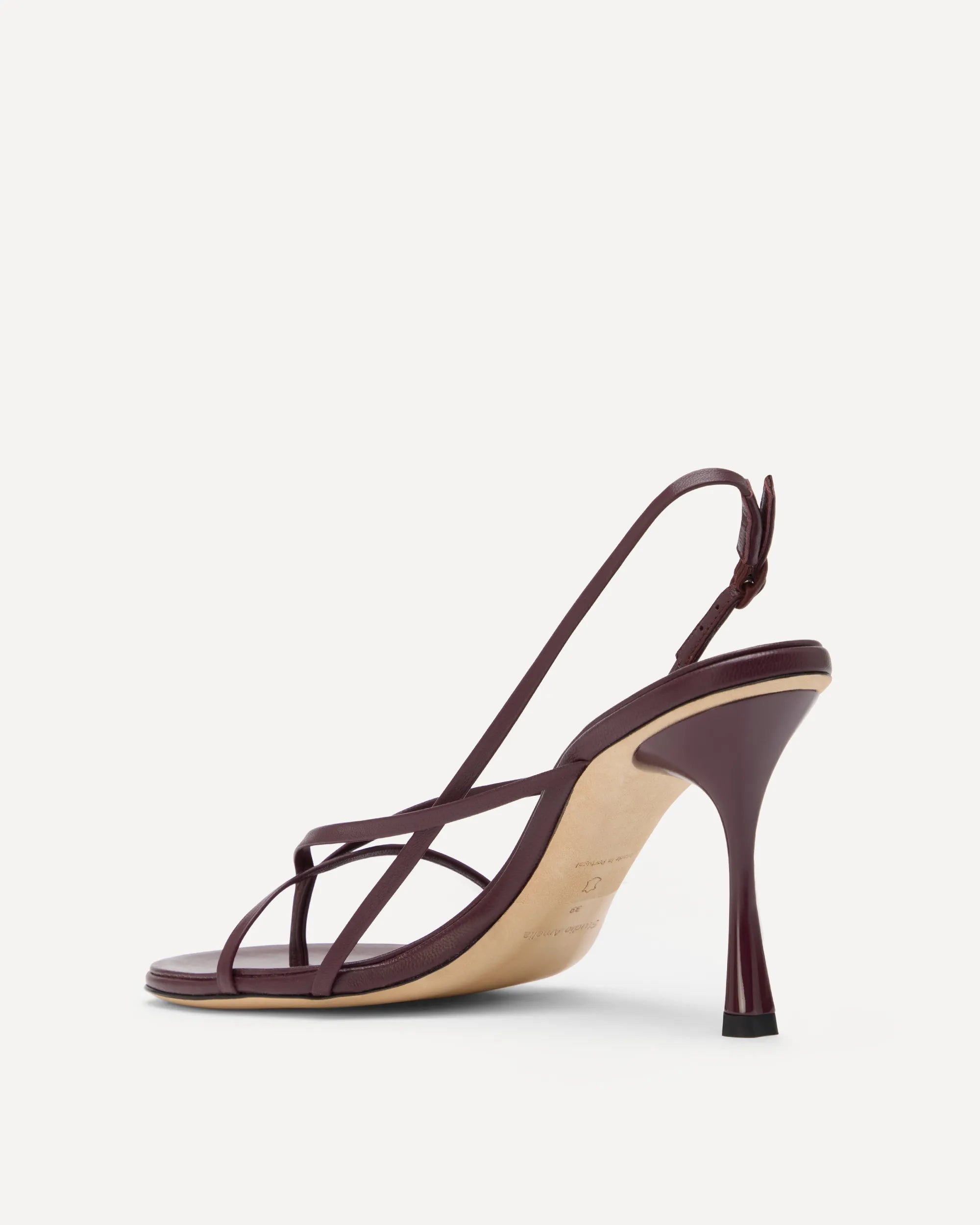 A single dark burgundy slingback high-heeled sandal with thin crisscross straps and a slim stiletto heel, shown from a side profile on a light gray background.